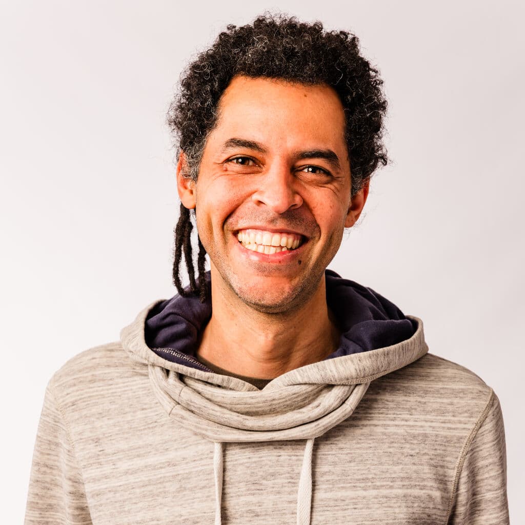 Sérgio Luciano sorrindo, usando uma bandana vermelha